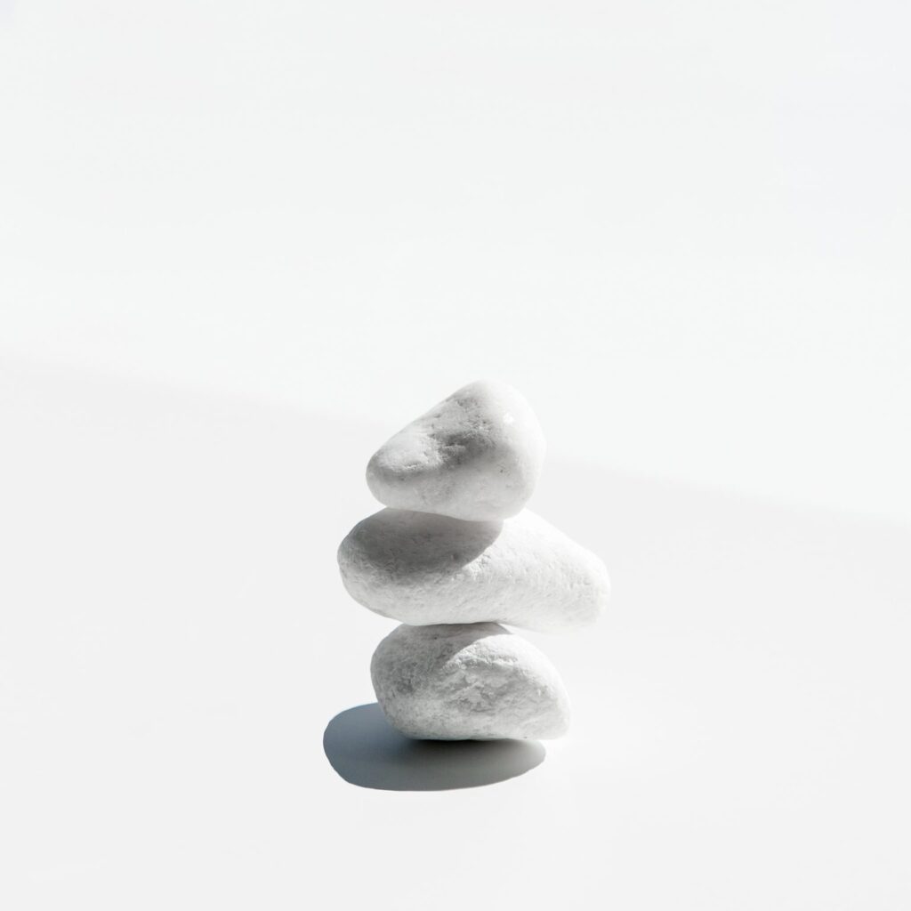 3 pebbles balance on top of each other. A simple feat meant to symbolize grace & balance in the face of change.